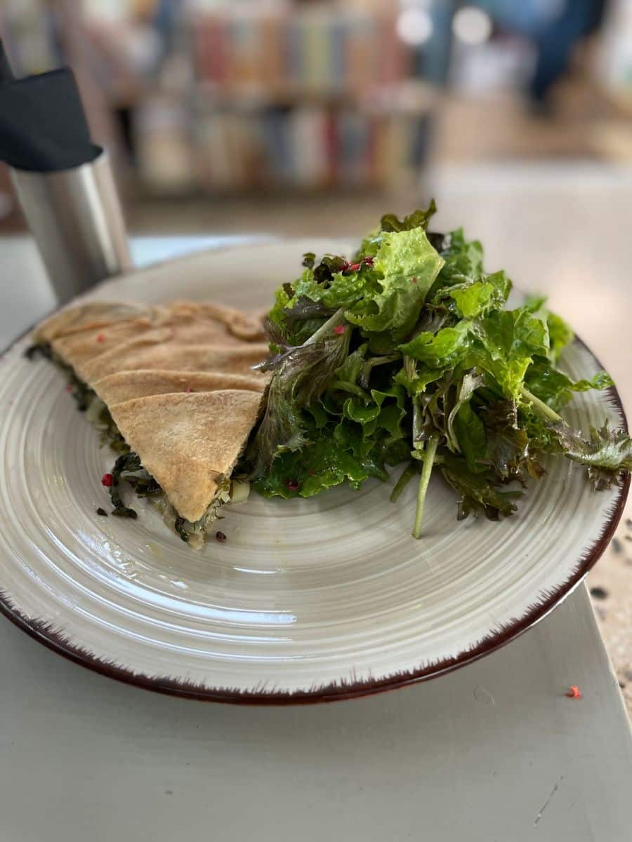 Traditional Greek spanakopita served with a fresh green salad during an Athens food tour tasting stop.