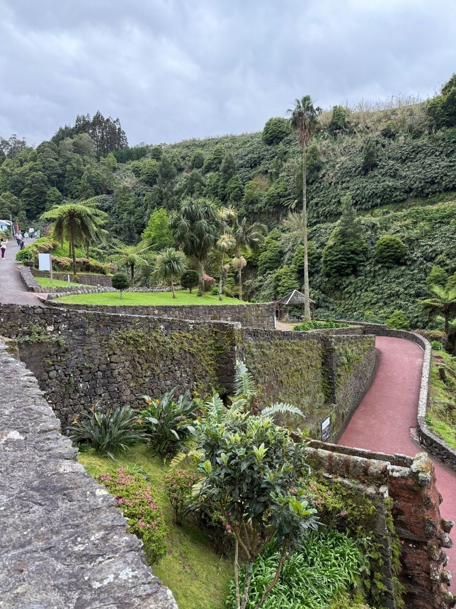 Terraced botanical garden in S&atilde;o Miguel, Azores with stone walls, winding paths, and tropical greenery set in a lush valley