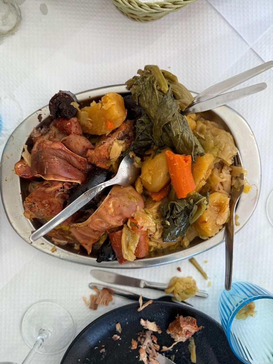 Traditional cozido das Furnas served in S&atilde;o Miguel, Azores with assorted meats, sausages, cabbage, carrots, and potatoes on a rustic dining table