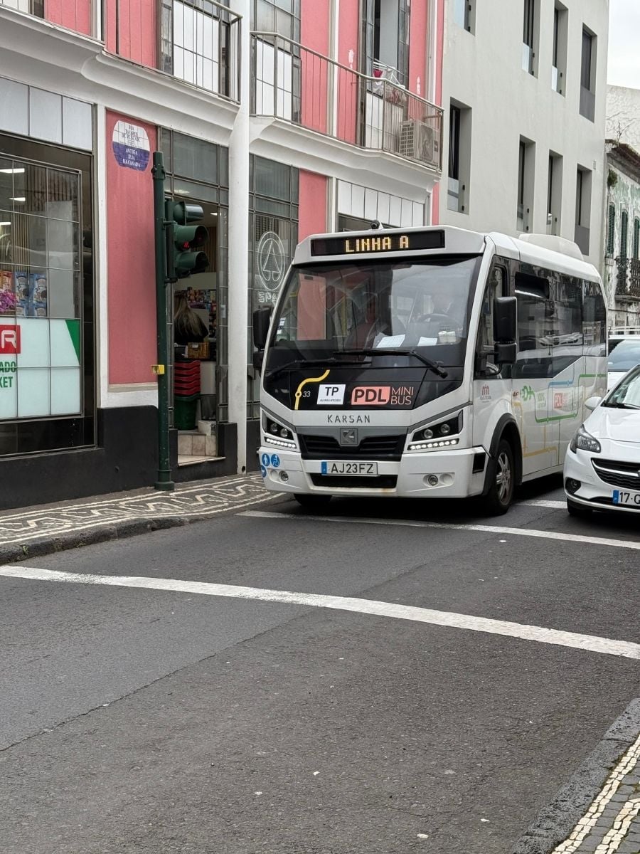 City street scene with a local mini bus and pastel buildings in Ponta Delgada, S&atilde;o Miguel, Azores showing everyday urban life