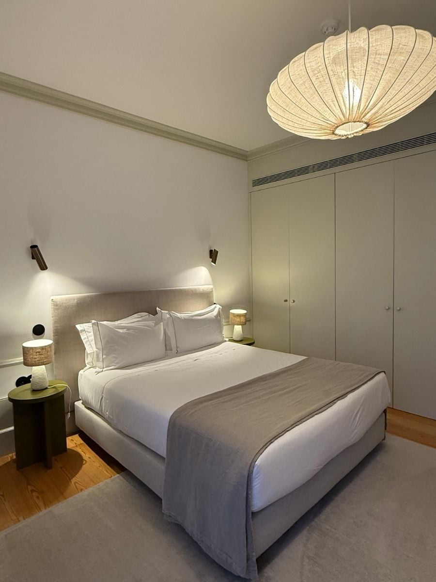 Minimalist hotel bedroom in S&atilde;o Miguel, Azores with soft lighting, neutral tones, and a neatly made bed creating a calm atmosphere