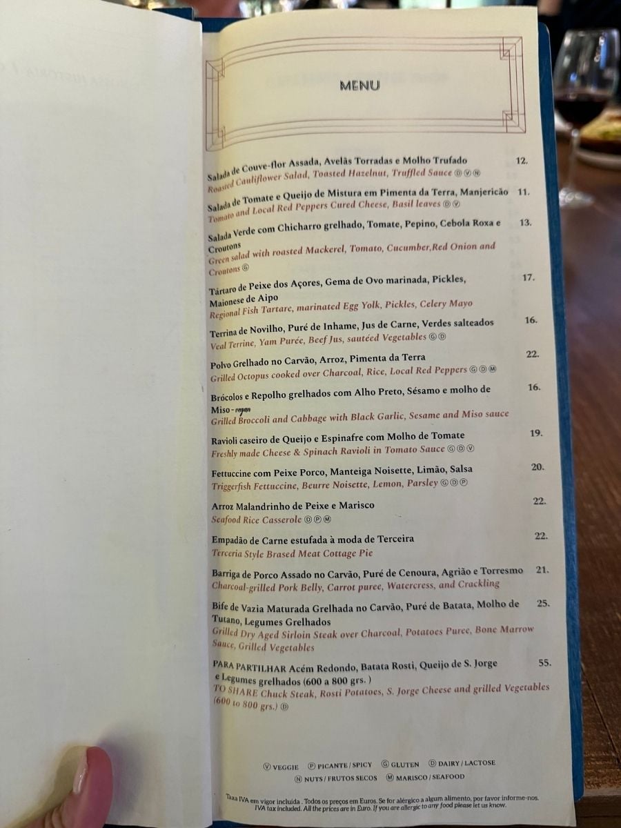Restaurant menu featuring local Azorean dishes and seafood options in S&atilde;o Miguel, Azores held at a dining table setting