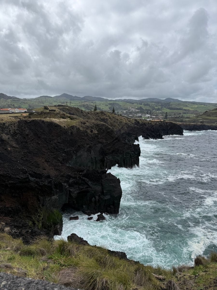 Dramatic coastal cliffs and crashing waves in S&atilde;o Miguel, Azores under overcast skies with rugged volcanic landscape