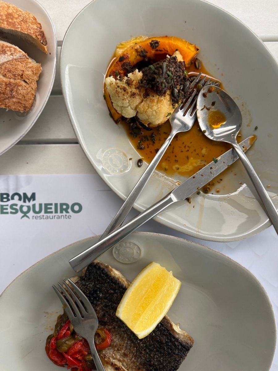 Grilled fish with lemon and roasted vegetables served at Bom Pesqueiro restaurant in S&atilde;o Miguel, Azores on a simple white plate