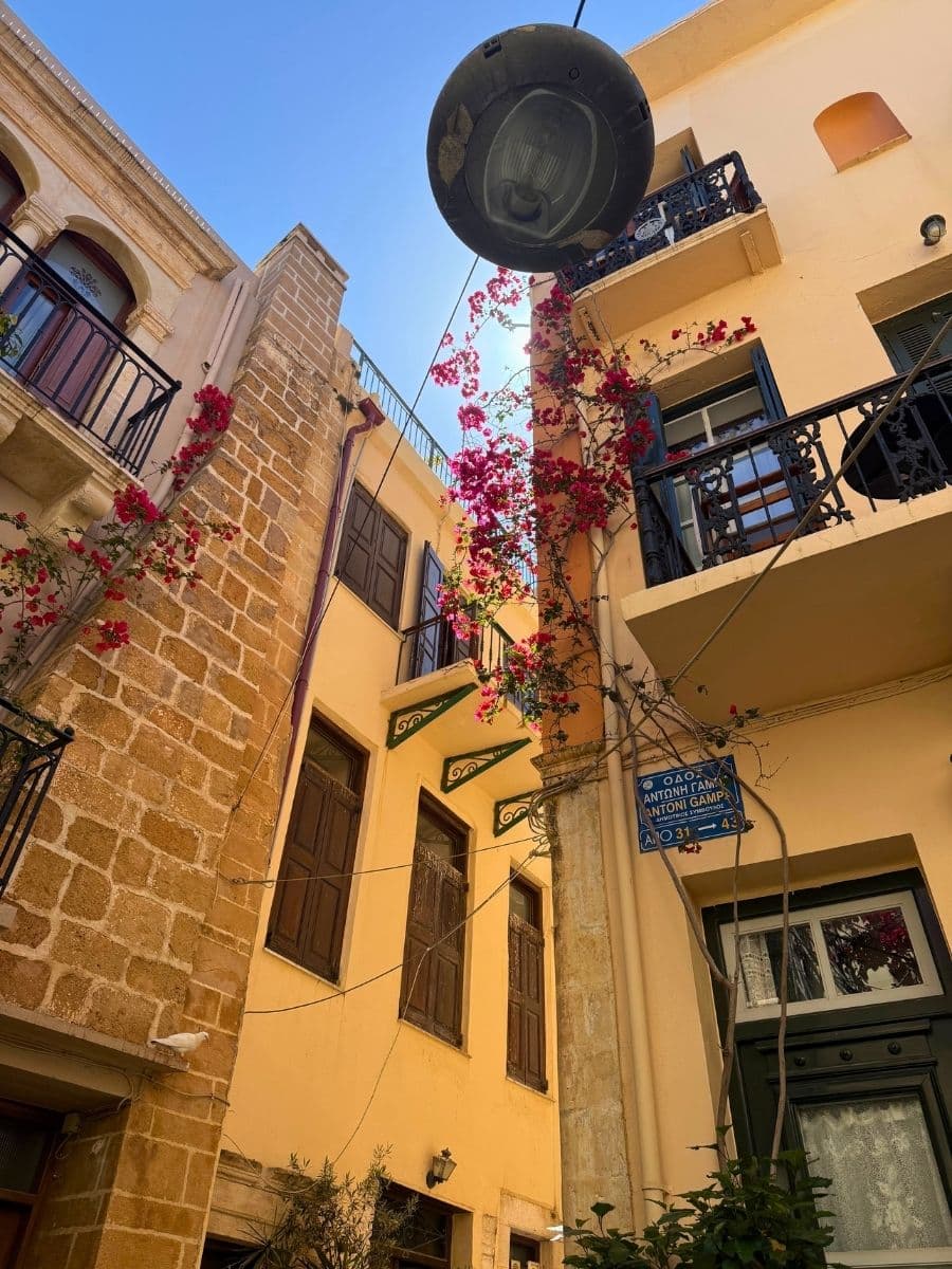Historic street in Chania Old Town, Crete, featuring blooming bougainvillea, Venetian architecture, and charming balconies.