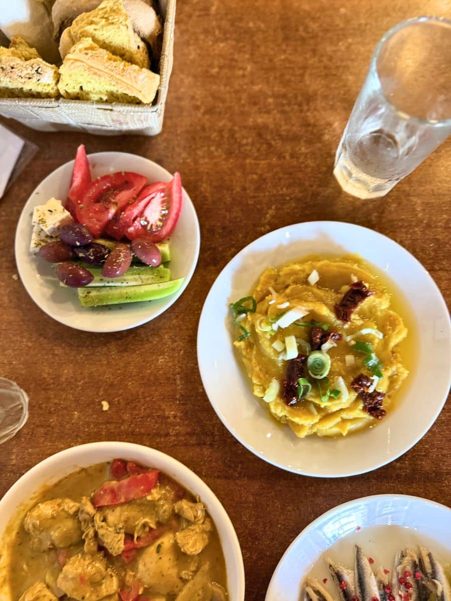 Traditional Cretan meze including Greek salad, hummus, anchovies, bread, and local dishes served at a restaurant in Heraklion, Crete.