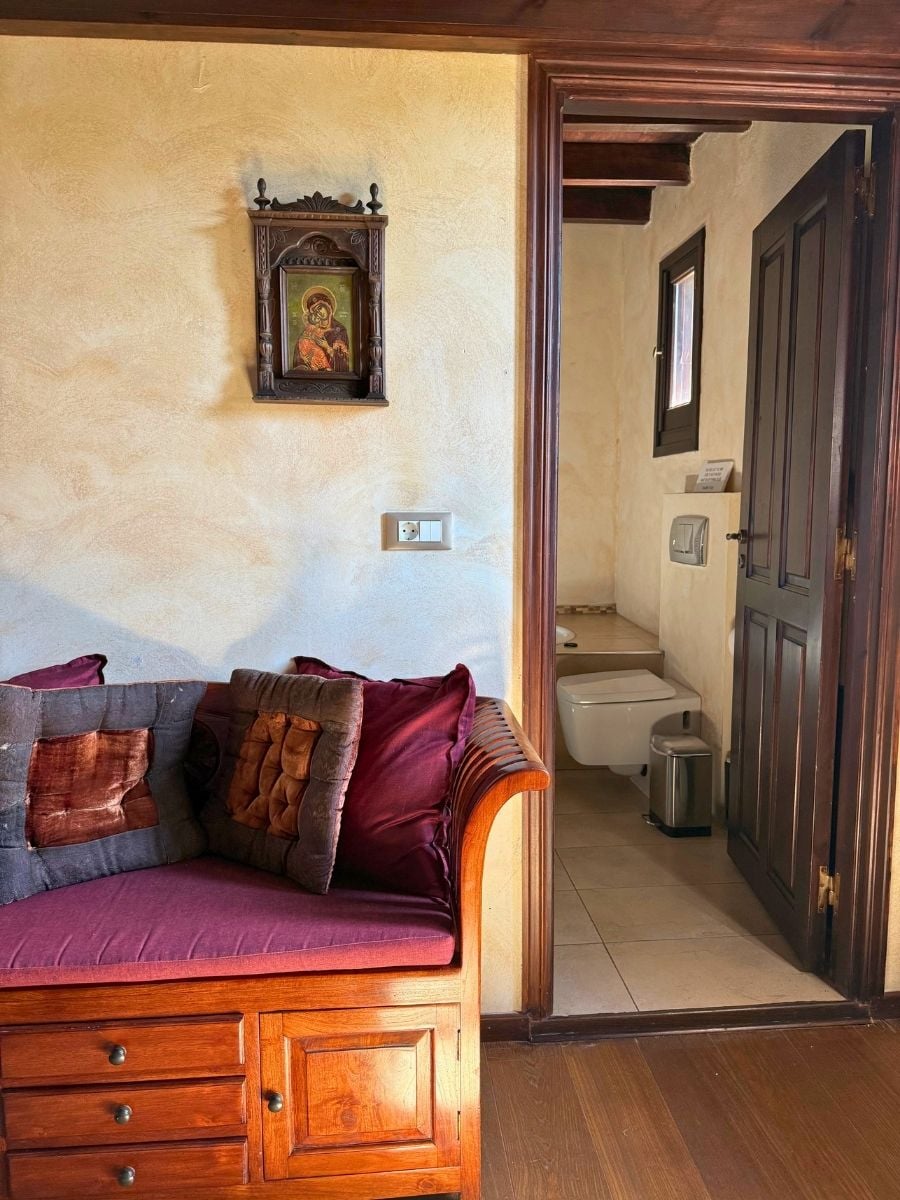 Cozy traditional guest room with wooden furnishings, warm décor, and an en-suite bathroom in Rhodes Old Town, Rhodes, Greece.